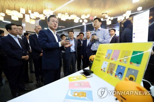 문재인 대통령이 지난해 8월 7일 서울시청 시민청에서 열린 인터넷 전문은행 규제혁신 현장방문 행사에 참석해 모바일 기기를 이용해 카카오 뱅크에서 전·월세 보증금을 대출받는 과정을 체험한 뒤 질문하고 있다. [사진= 연합뉴스]