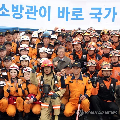 문재인 대통령이 2017년 11월 3일 충남 천안시 중앙소방학교에서 열린 제55주년 소방의날 기념식 행사에서 소방대원들과 기념 촬영을 하고 있다. [사진= 연합뉴스]