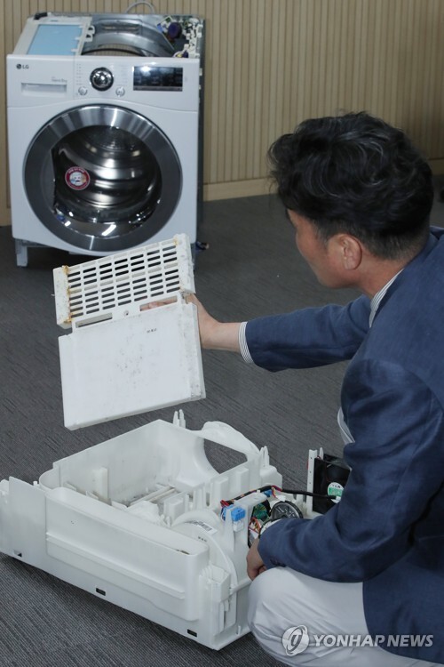 지난 8월 29일 서울 송파구 한국소비자원 서울지원에서 관계자가 건조기에 먼지가 쌓이는 원리를 설명하고 있다. [사진= 연합뉴스]
