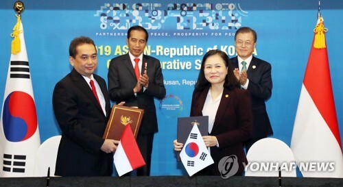 유명희 통상교섭본부장과 아구스 인도네시아 통상부 장관이 25일 오후 부산 한 호텔에서 문재인 대통령과 조코 위도도 인도네시아 대통령이 지켜보는 가운데 포괄적경제동반자협정(CEPA) 타결 공동선언문에 서명한 뒤 기념촬영을 하고 있다. [사진= 연합뉴스]