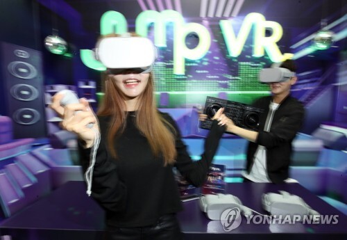 지난해 11월 19일 서울 중구 SK T타워에서 SK텔레콤 모델들이 다수의 가상현실(VR) 이용자들이 시공간을 초월한 '가상 세계'에서 타인들과 관계를 형성해 나가는 5G VR 서비스인 '버추얼 소셜 월드'를 홍보하고 있다. [사진= 연합뉴스]