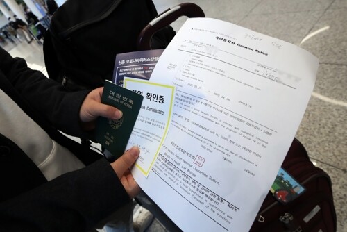 영국 런던발 입국자가 24일 오후 인천국제공항 2터미널에서 격리통지서와 검역확인증을 들고 공항 입국장을 빠져나가고 있다. [사진= 연합뉴스]