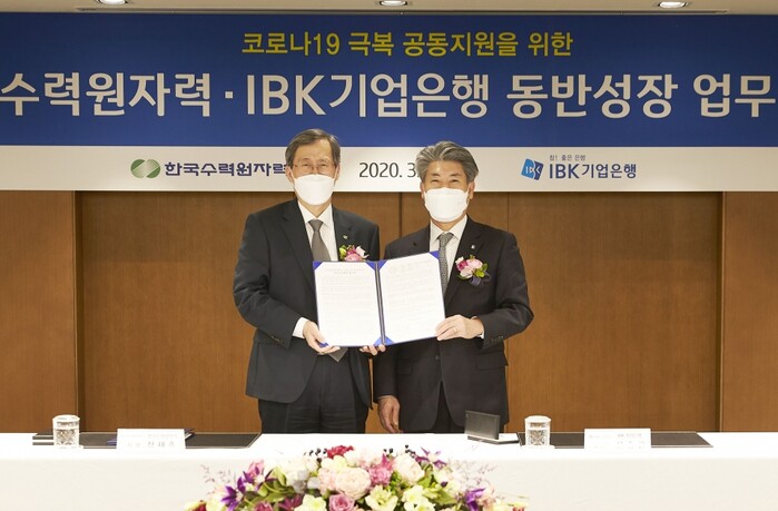 윤종원 IBK기업은행장(오른쪽)과 정재훈 한국수력원자력 사장(왼쪽)이 동반성장 업무 협약식을 마치고 기념촬영을 하고 있다.(사진=IBK기업은행장)