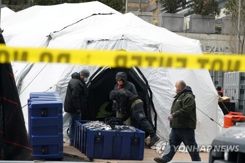 미국 뉴욕 맨해튼의 한 병원 야외에서 지난 25일(현지시간) 인부들이 신종 코로나바이러스 감염증(코로나19) 사망자 시신을 안치할 임시영안실 설치 작업을 하고 있다. [사진= 로이터/연합뉴스]?
