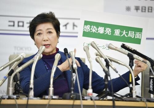 고이케 유리코 도쿄도 지사가 이달 25일 오후 도쿄도청에서 긴급 기자회견을 하던 중 '감염폭발 중대국면'이라고 쓴 카드를 들어 보이고 있다. [사진= 연합뉴스]