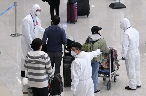 9일 오후 인천국제공항 2터미널에서 독일 프랑크푸르트, 영국 런던 등 유럽발 항공편 입국자들이 방역 관계자들로부터 자차 이동, KTX를 이용한 지방 이동 등에 대한 안내를 받고 있다. [사진= 연합뉴스]