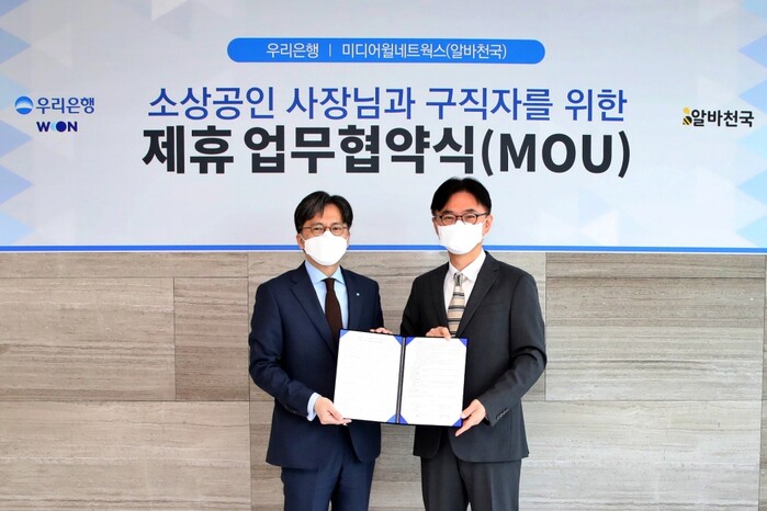 황원철(왼쪽) 우리은행 디지털금융그룹 상무가 공선욱 미디어월네트웍스 대표와 기념촬영을 하고 있다.(사진=우리은행)