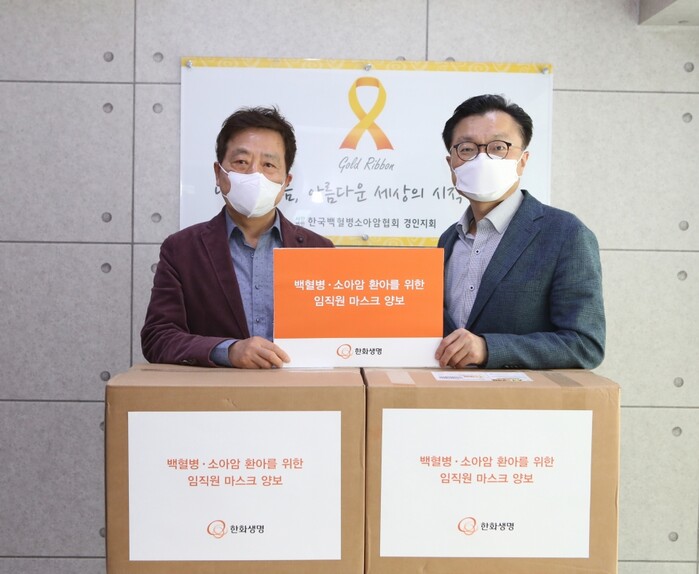 한화생명 홍보실장 김영식(오른쪽)과 한국백혈병소아암협회 경인지회 정영기 지회장(왼쪽)이 캠페인으로 모인 보건용 마스크 3208장앞에서 기념촬영을 하고 있다. 한화생명은 2014년부터 지금까지 ‘VIP 서비스 기부제도’를 통해 한국백혈병소아암협회 경인지회와 다양한 기부활동을 이어왔다.(사진=한화생명)