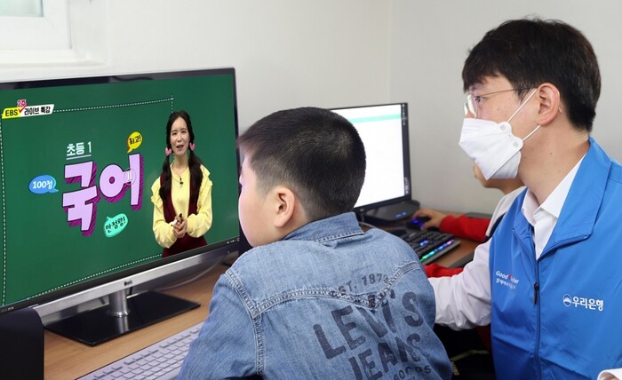 우리금융그룹은 코로나19 장기화로 온라인개학을 했지만, 학습기기 부족으로 수업에 어려움을 겪고 있는 취약계층 아동을 돕기 위해 전국 410개 그룹홈에 컴퓨터 및 교육 컨텐츠 지원, 보조교사 파견 등을 지원한다. 우리금융그룹 자원봉사단원이 그룹홈 아동과 함께 그룹홈 공부방에서 온라인 수업을 듣고 있다.(사진=우리금융그룹)