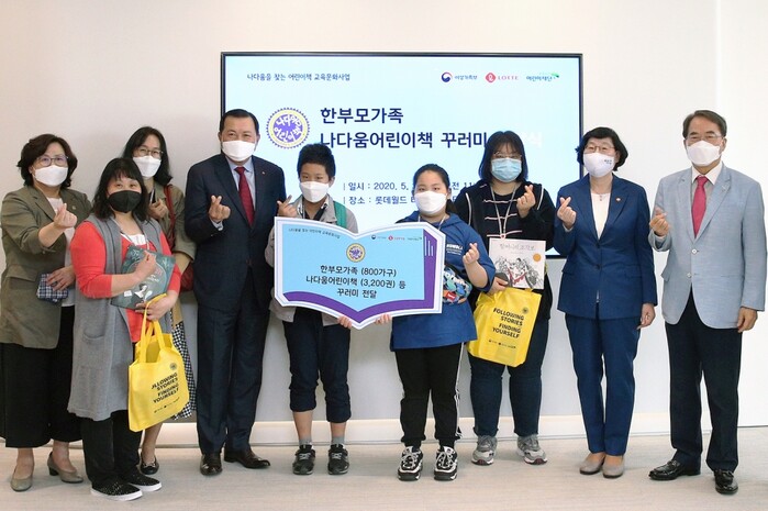 25일 롯데월드타워에서 진행된 ‘나다움 어린이책’ 전달식에서 여성가족부 이정옥 장관(오른쪽 두번째), 초록우산어린이재단 이제훈 회장(오른쪽 첫번째), 롯데지주 황각규 부회장(왼쪽 네번째)이 행사에 참여한 한부모 가족 5명에게 ‘나다움 어린이책 꾸러미’를 전달하고 기념촬영을 하고 있다.(사진=롯데그룹)