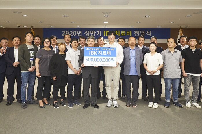 사진은 8일 을지로 기업은행 본점에서 윤종원 은행장(왼쪽 열한 번째)과 중소기업 근로자 가족들이 치료비 전달식을 마치고 기념촬영을 하고 있는 모습.(사진=IBK기업은행)