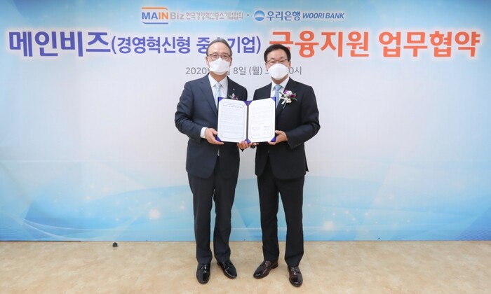박완식(오른쪽) 우리은행 중소기업그룹장이 석용찬 메인비즈협회장과 기념촬영을 하고 있다.(사진=우리은행)
