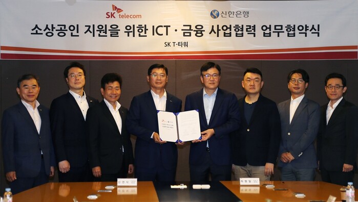 24일 서울시 중구 을지로 소재 SKT타워에서 진행된 업무 협약식에서 신한은행 신연식 부행장(왼쪽)과 하형일 SK텔레콤 코퍼레이트2센터장이 기념촬영 하는 모습