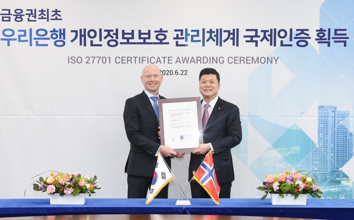 우리은행은 국제표준 개인정보보호 인증인 ‘ISO27701’ 를 금융권 최초로 획득했다. 권광석 우리은행장(오른쪽)이 프로데 술베르그 주한 노르웨이 대사와 지난 22일 우리은행 본점에서 열린 인증서 수여식에서 기념촬영을 하고 있다.(사진=우리은행)