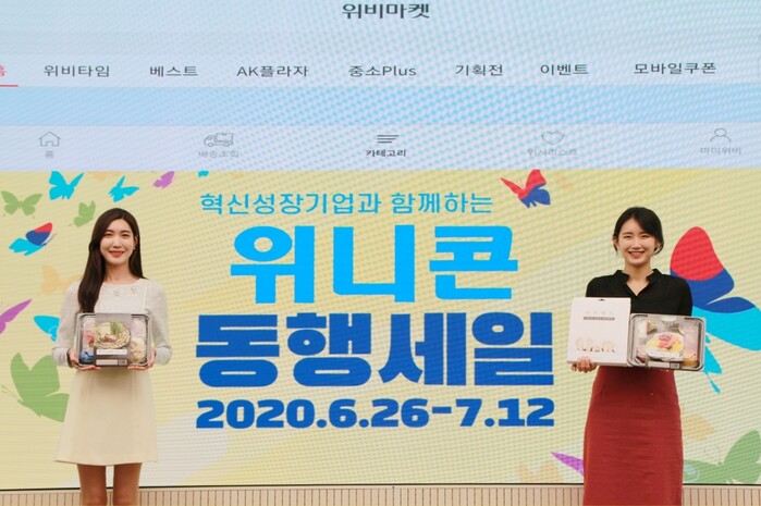 우리금융그룹은 코로나19 장기화로 매출감소, 판로확보 등에 어려움을 겪고 있는 혁신성장기업을 지원하기 위해 ‘위니콘 동행세일’을 다음달 12일까지 진행한다. 우리카드의 오픈마켓형 쇼핑몰 ‘위비마켓’ 을 배경으로 우리금융그룹 직원들이 위니콘 동행세일에 판매될 제품을 홍보하고 있다.(사진=우리금융그룹)