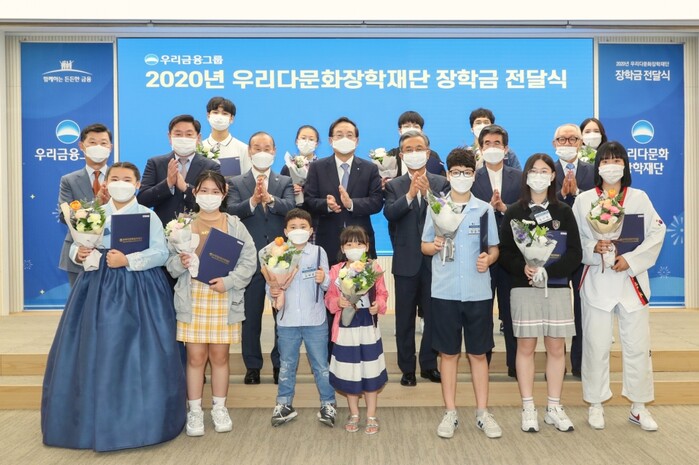 우리금융그룹 우리다문화장학재단은 30일 서울 중구 우리은행 본점에서 ‘2020년 다문화 학생 장학금 전달식’을 갖고 다문화 장학생 430명에게 총 6억3000만원의 장학금을 전달했다. 이날 행사에서 손태승(사진 가운데) 우리금융그룹 회장 겸 우리다문화장학재단 이사장과 이사진, 그리고 장학생 대표 12명이 기념촬영을 하고있다.(사진=우리금융그룹)