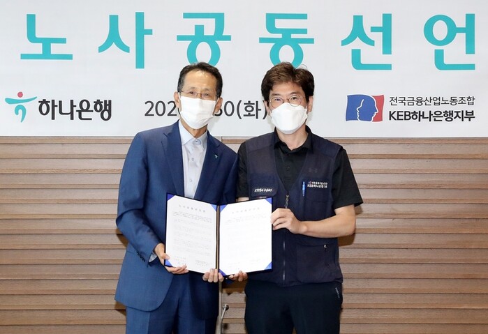 30일 오전 을지로 하나은행 본점에서 지성규 은행장(왼쪽)과 최호걸 노조위원장이 노사 공동선언문에 서명하고 기념촬영을 하고 있다.(사진=하나은행)