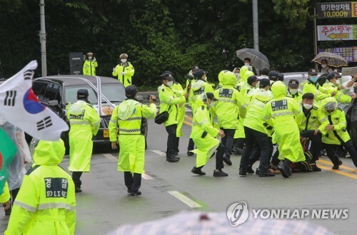 15일 오전 대전시 유성구 국립현충원에서 고 백선엽 장군의 대전 국립현충원 안장을 반대하는 진보단체 집회(왼쪽)와 길을 막고 있는 한 보수 단체의 차량 사이로 경찰이 사고에 대비하고 있다. [사진= 연합뉴스]