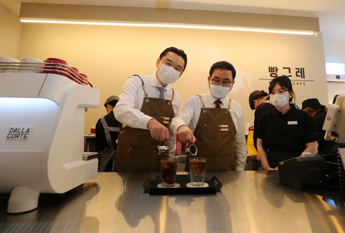 하이트진로 김인규 대표(왼쪽)와 창원시 허성무 시장(오른쪽)이 빵그레에서 함께 음료를 제조하고 있다.(사진=하이트진로)
