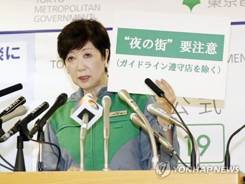 고이케 유리코(小池百合子) 도쿄도(東京都) 지사가 7월 2일 기자회견에서 '밤의 거리 요주의'라고 적힌 팻말을 들어 올리고 있다. [도쿄= 교도/연합뉴스]